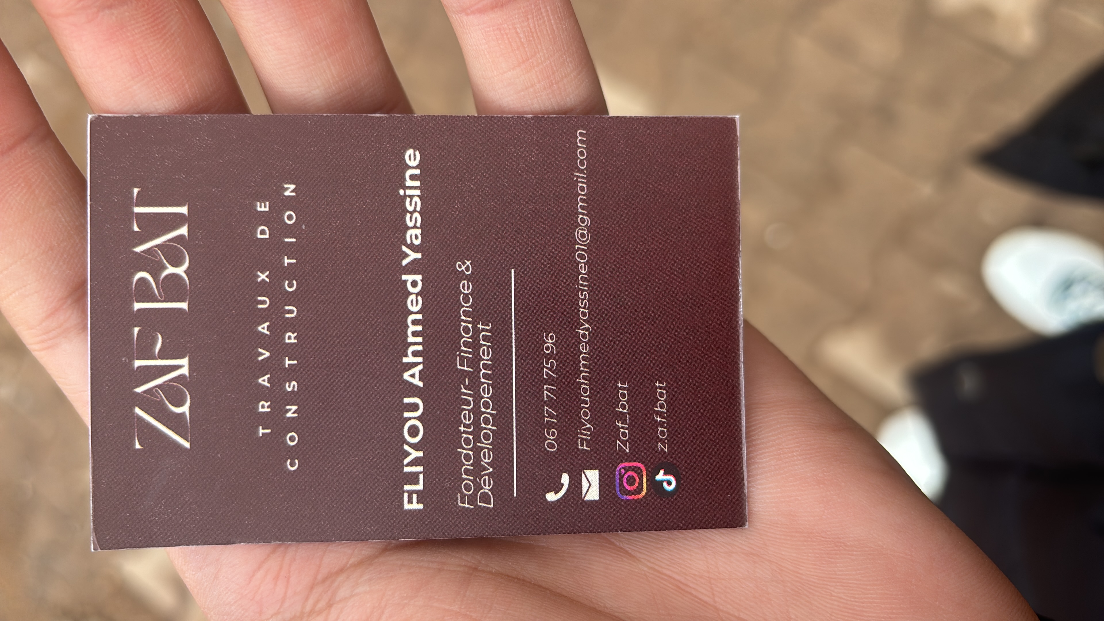 Carte de visite ZAF BAT tenue en main sur un chantier