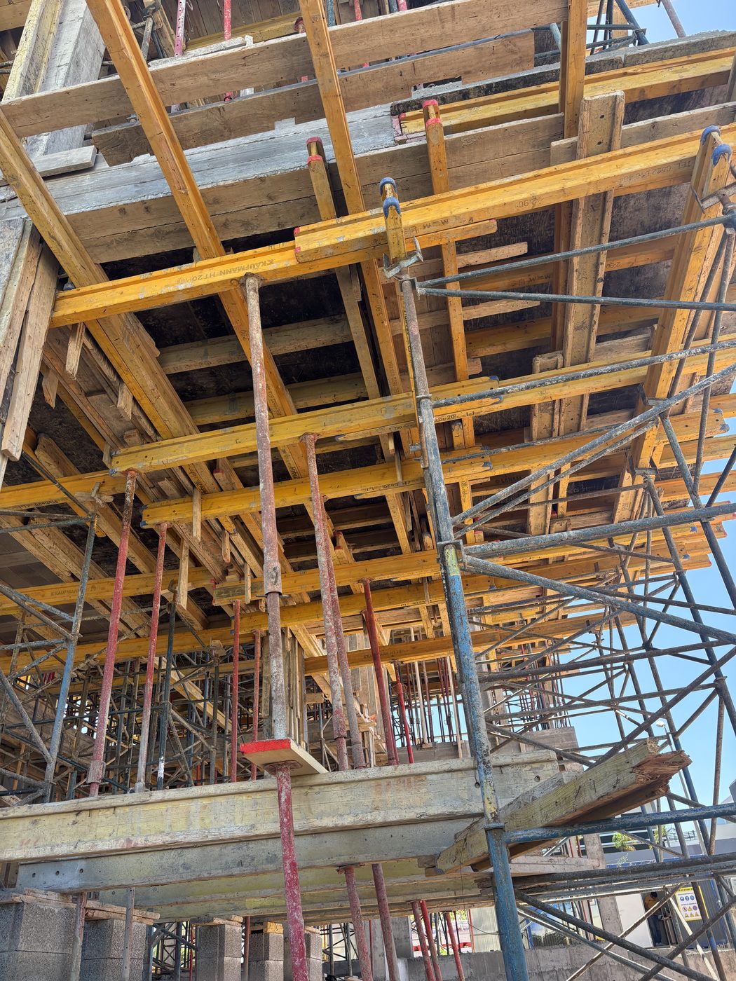 Échafaudage jaune et coffrage sous dalle béton d'un bâtiment en construction