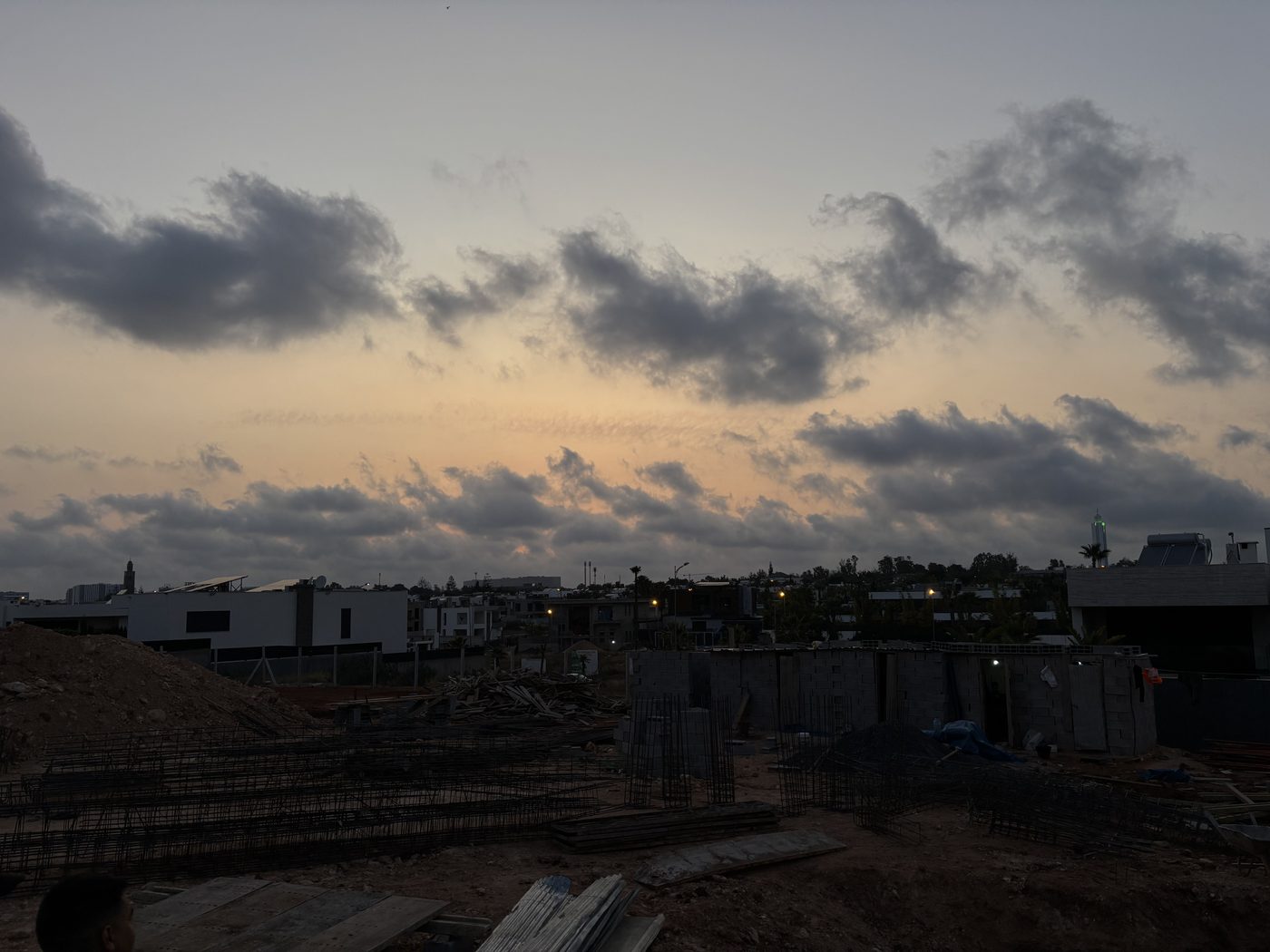 Piscine en eau au premier plan et équipe présente devant l'ouvrage annexe en construction